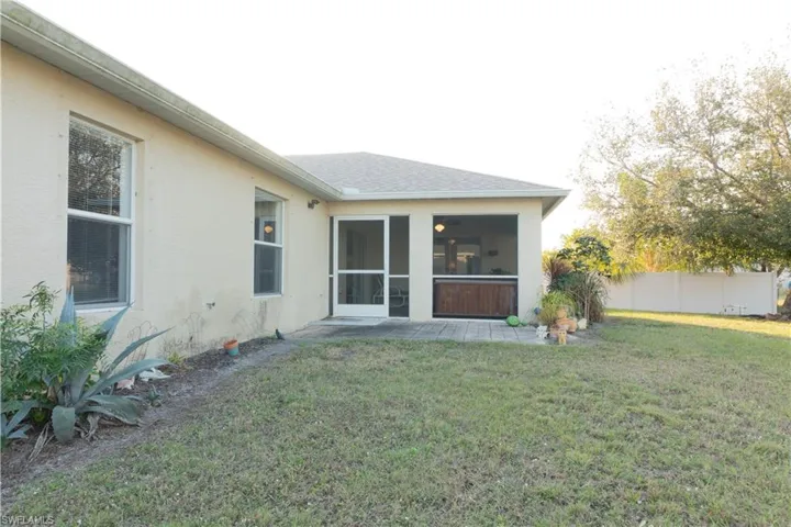 Rear view of house with a sunroom and a yard