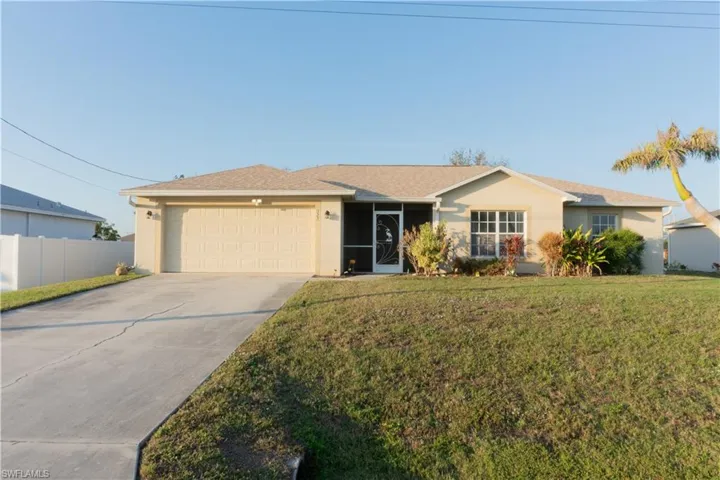 Ranch-style home featuring a garage and a front lawn