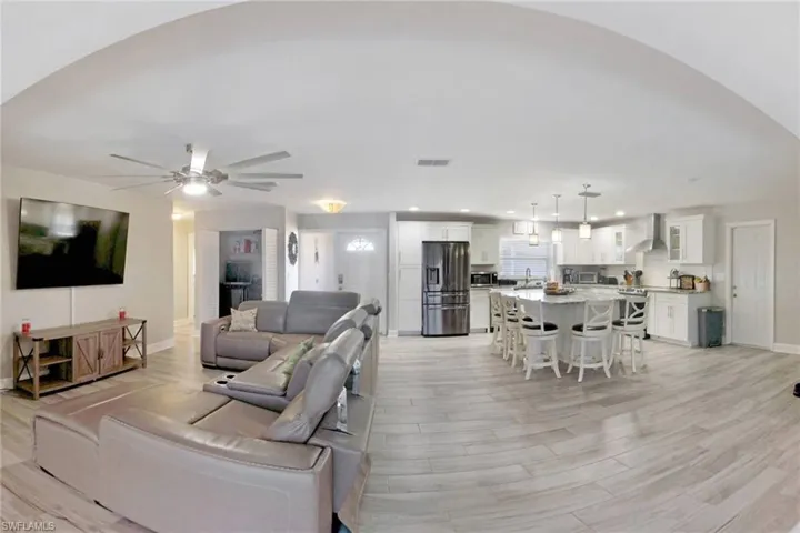 Living room featuring light wood-style floors, ceiling fan, and recessed lighting