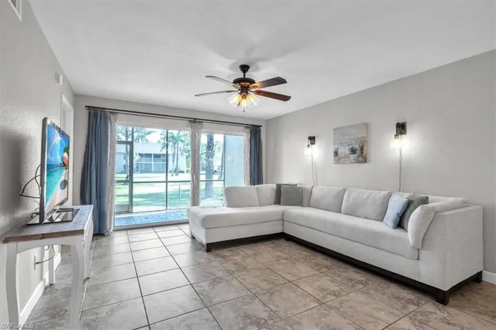 Living room featuring ceiling fan and baseboards