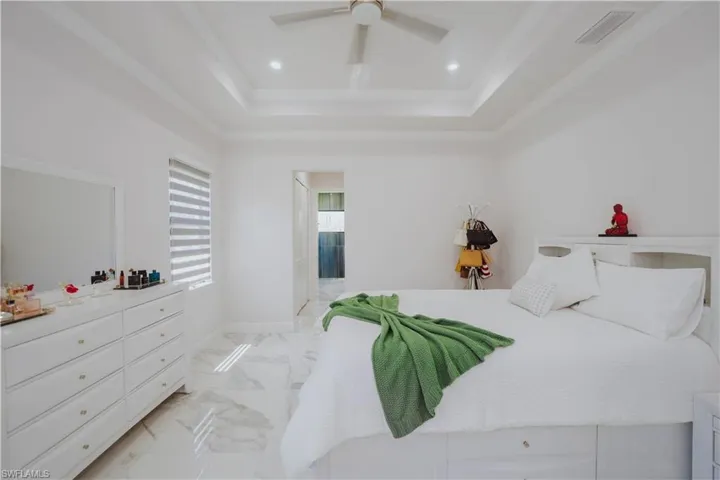 Bedroom with a raised ceiling, ceiling fan, crown moldin/Users/zavier/Downloads/highlights-2/dji_fly_20240525_103844_982_1716647936899_photo.JPGg, and light tile flooring