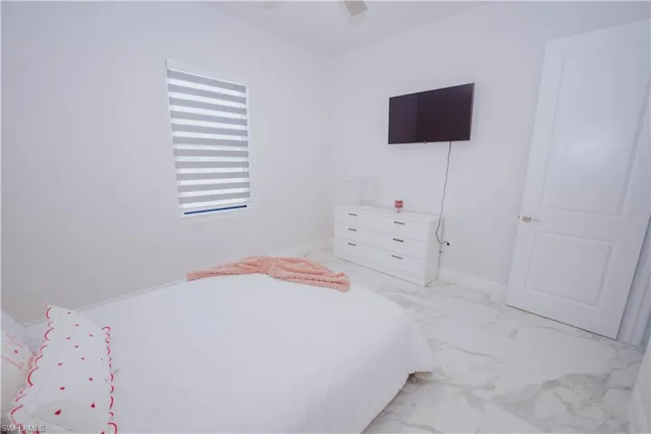 Bedroom featuring ceiling fan and light tile floors