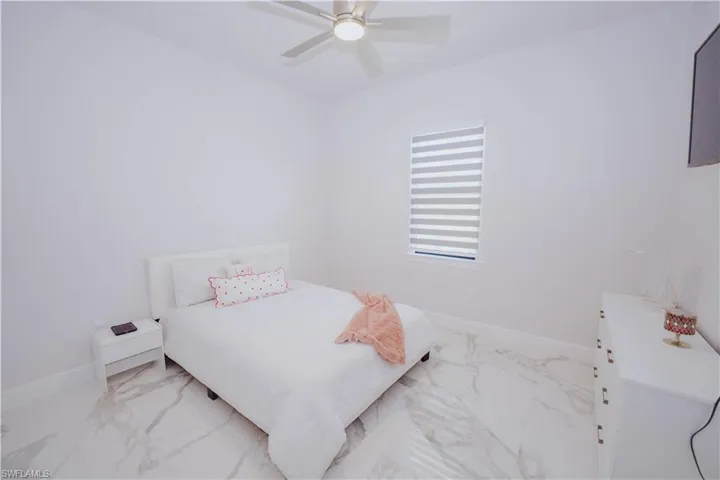 Bedroom featuring ceiling fan and light tile floors