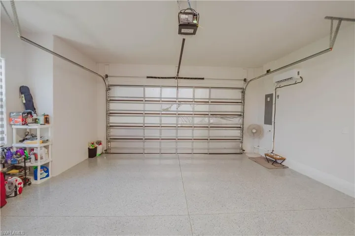 Garage with a garage door opener and a wall mounted AC