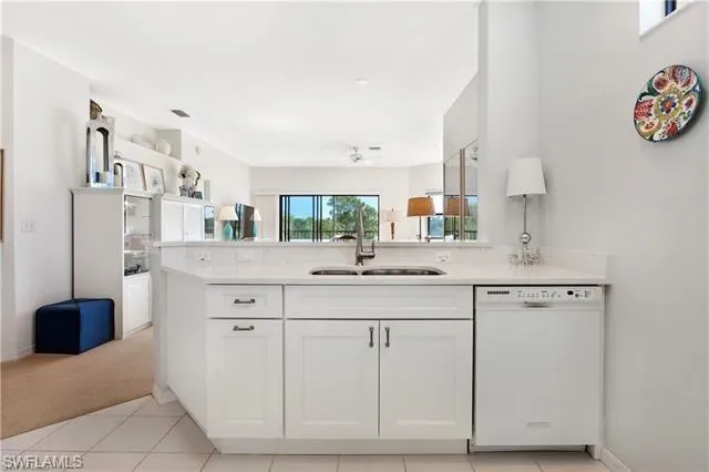 Kitchen with dishwasher, white cabinetry, light countertops, and light tile patterned floors