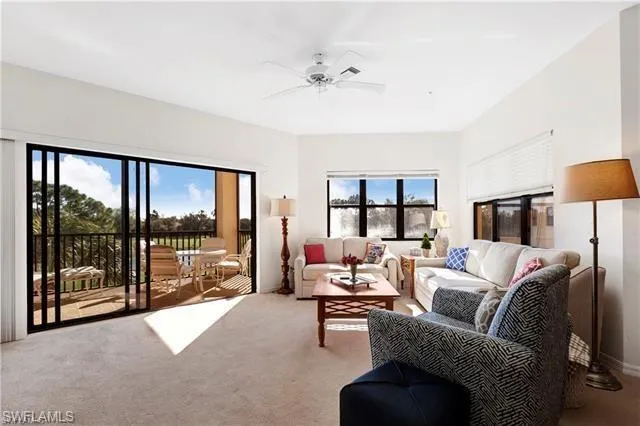Living area with light carpet and ceiling fan