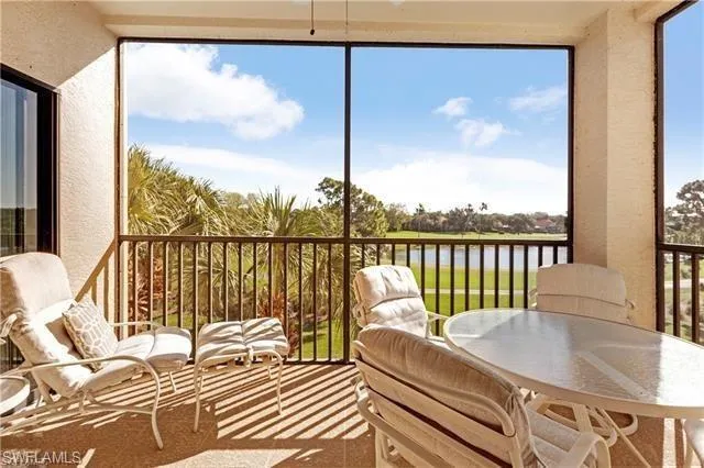 Sunroom featuring a water view and a textured wall