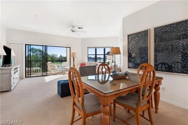 Dining room with light colored carpet and ceiling fan