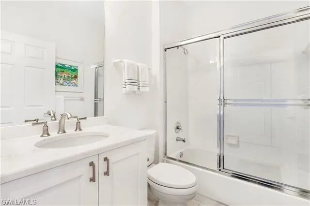 Bathroom with vanity and enclosed tub / shower combo