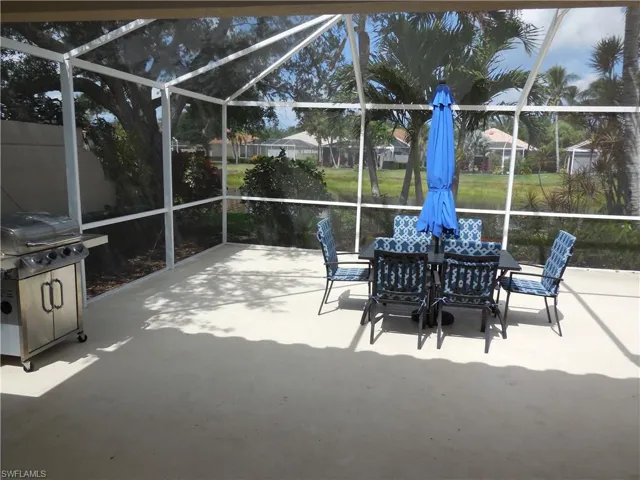 View of patio / terrace with glass enclosure, outdoor dining space, and a grill