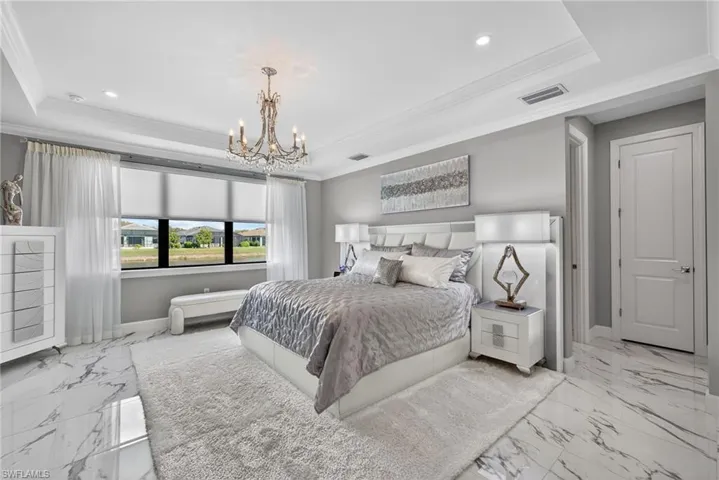 Bedroom with crown molding, a raised ceiling, a chandelier, and recessed lighting