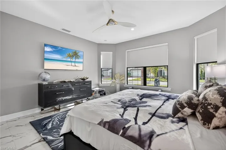 Bedroom featuring marble look tiles and a ceiling fan