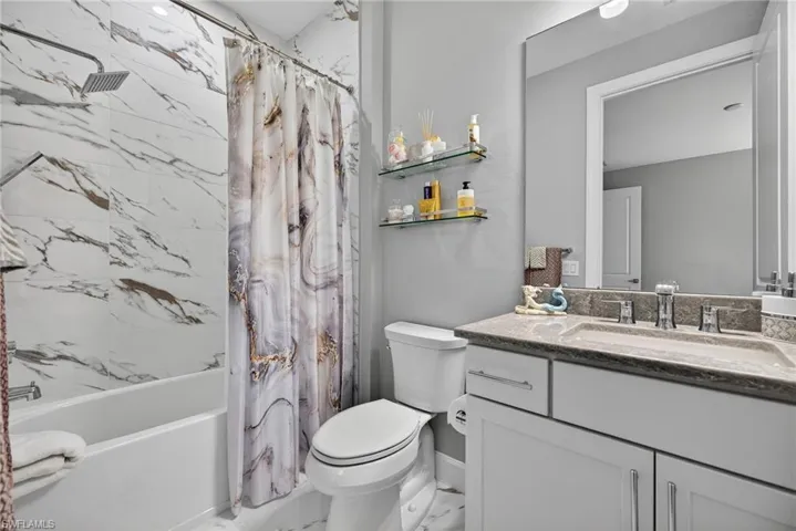 Full bath featuring shower / bath combo and vanity
