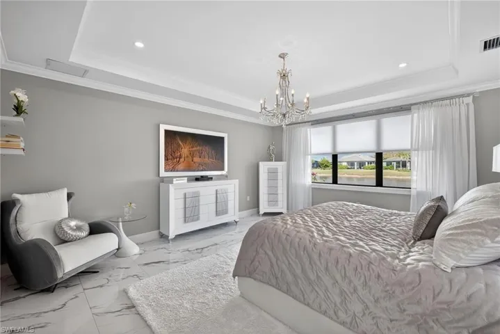 Bedroom with ornamental molding, marble look tiles, a chandelier, and recessed lighting