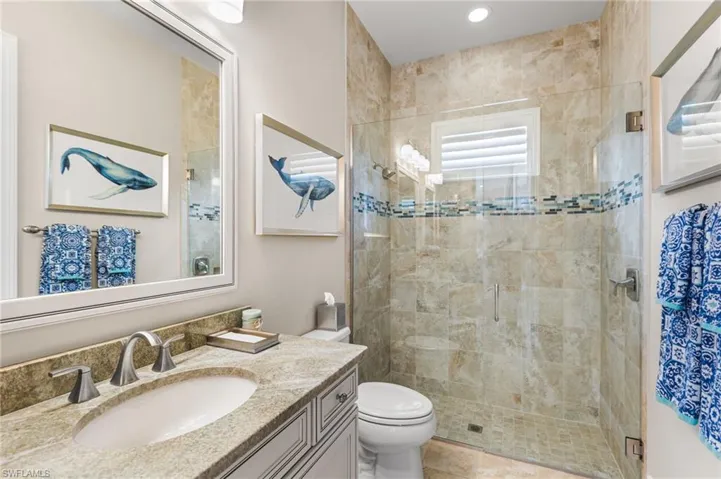 Bathroom with vanity, toilet, and a shower with door