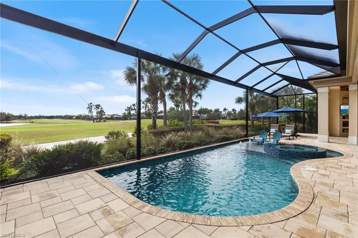 View of swimming pool featuring a lanai, a patio, and an in ground hot tub