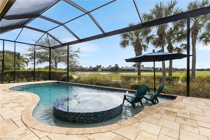 View of pool with an in ground hot tub, a lanai, and a patio
