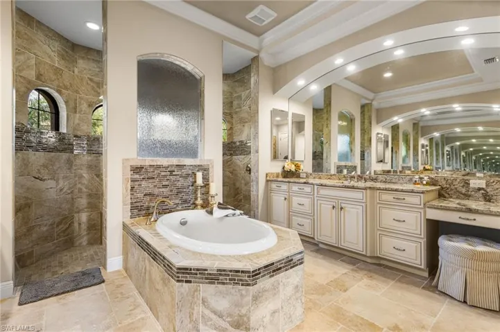 Bathroom featuring vanity, separate shower and tub, and ornamental molding