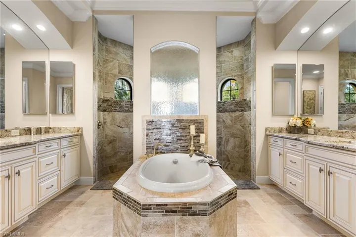 Bathroom with ornamental molding, vanity, and independent shower and bath