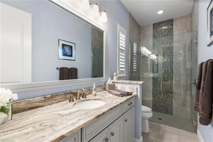 Bathroom with vanity, an enclosed shower, tile patterned floors, and toilet