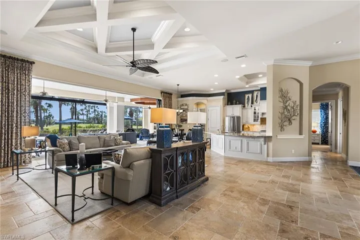Living room with beamed ceiling, crown molding, coffered ceiling, and ceiling fan
