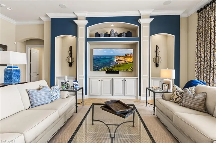 Living room featuring decorative columns and ornamental molding