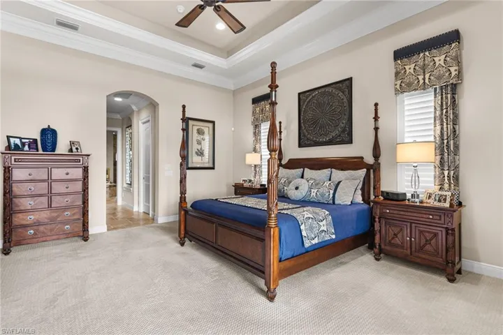 Carpeted bedroom featuring crown molding and ceiling fan