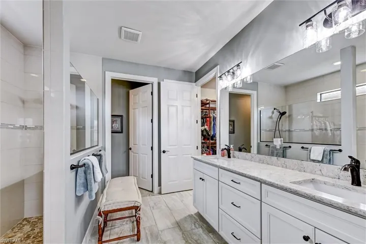 Bathroom with vanity and tiled shower