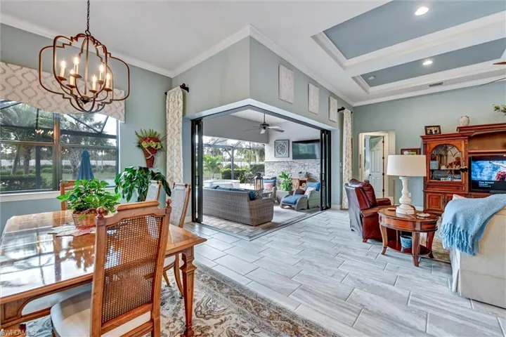 Dining room featuring ceiling fan with notable chandelier and crown molding