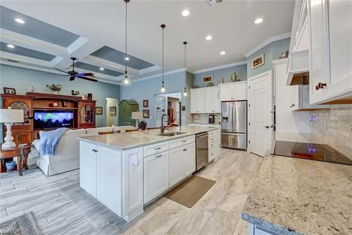 Kitchen featuring an island with sink, white cabinets, sink, and appliances with stainless steel finishes