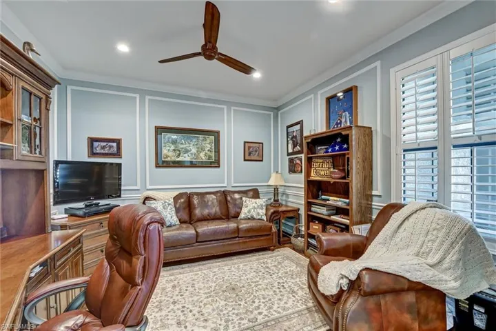 Living room featuring ceiling fan and crown molding