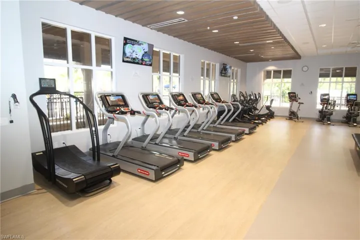Workout area with wooden ceiling and light hardwood / wood-style floors