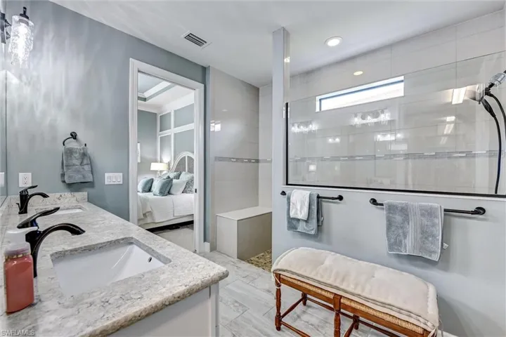 Bathroom with tiled shower and vanity