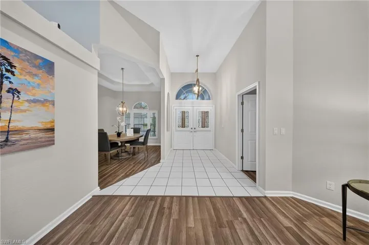 Grand double-door entry with arched transom and volume ceilings sets a bright, airy tone.