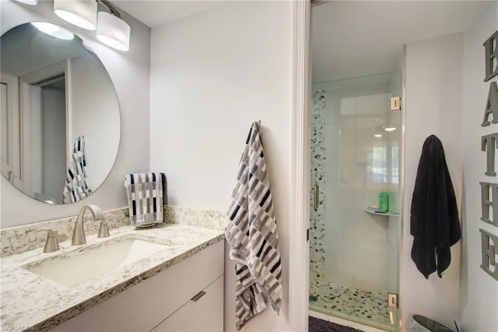 Full bath featuring vanity and a shower stall