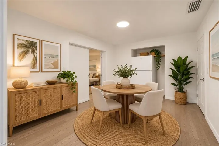 Dining area featuring wood-finish flooring, a recessed appliance nook, and a sliding door