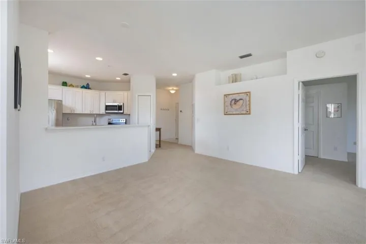 Unfurnished living room with light carpet and recessed lighting