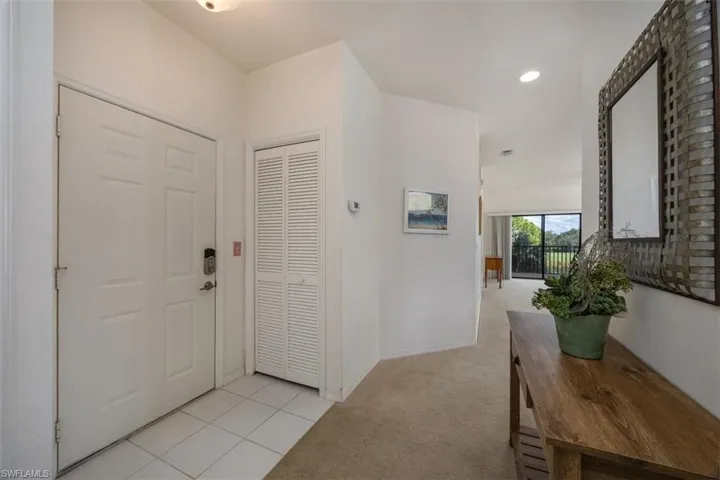 Entryway with light tile patterned floors, light colored carpet, and recessed lighting