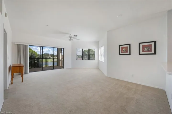 Unfurnished living room with light colored carpet and ceiling fan