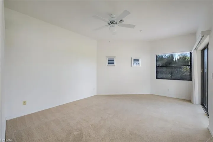 Empty room featuring light carpet and ceiling fan