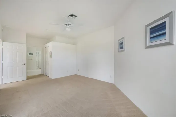 Unfurnished bedroom with light colored carpet and ceiling fan