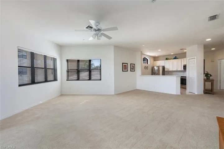 Unfurnished living room featuring recessed lighting, light colored carpet, and ceiling fan