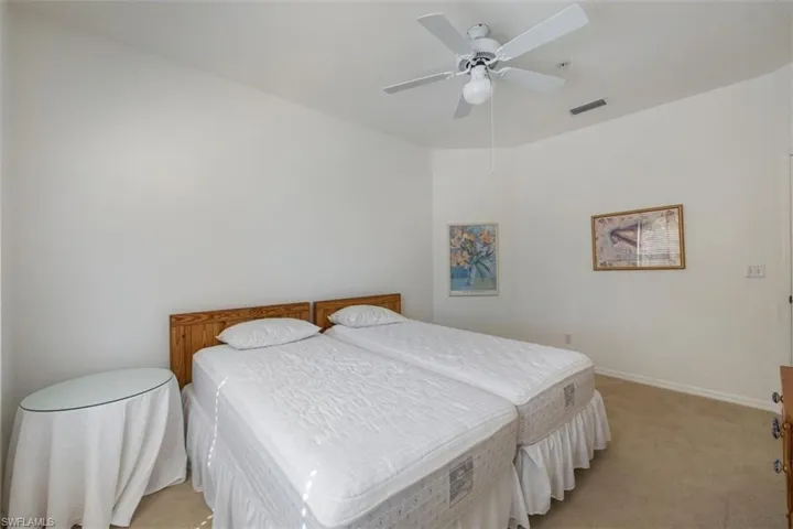 Carpeted bedroom with ceiling fan and baseboards