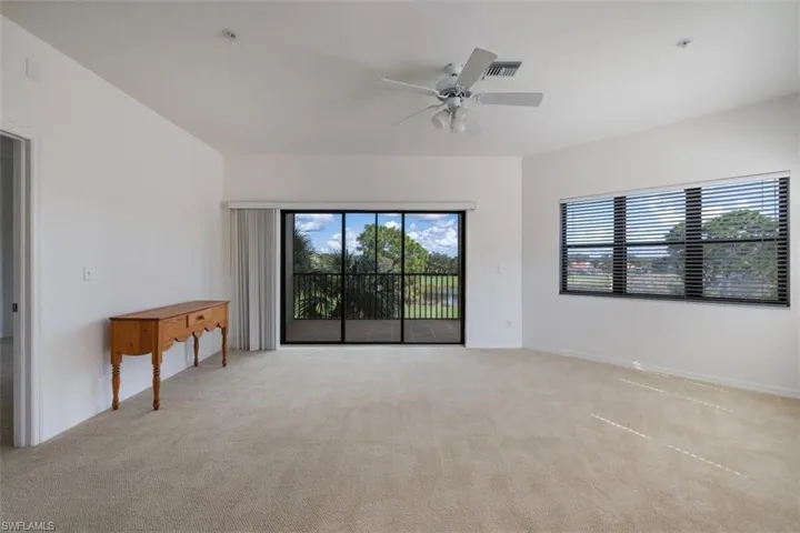 Empty room featuring light colored carpet and a ceiling fan