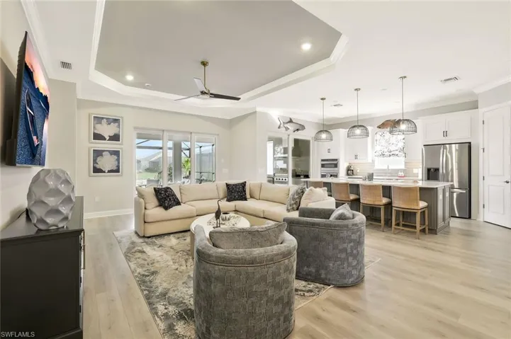 Living room featuring light wood-style floors, crown molding, a ceiling fan, and recessed lighting