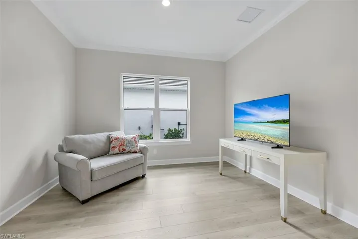 Living area featuring light wood-style floors and crown molding