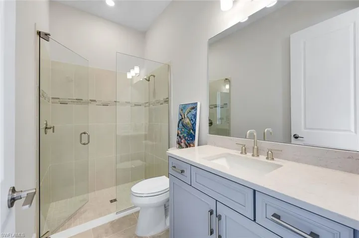 Full bathroom with vanity, a stall shower, and light tile patterned floors