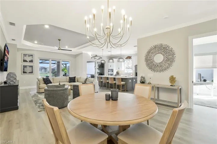 Dining space featuring a chandelier, crown molding, light wood-type flooring, a ceiling fan, and recessed lighting