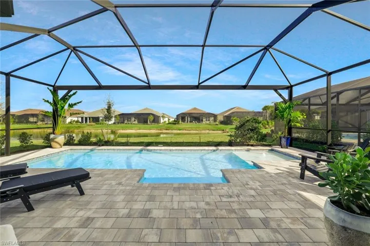 Outdoor pool featuring a sunroom, a lanai, a patio area, a residential view, and a lawn