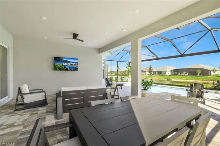 View of patio / terrace with a sunroom, outdoor dining area, an outdoor pool, and an outdoor hangout area